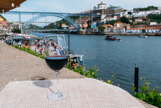 蔡斯里贝拉廷托葡萄牙波尔图杜罗河上俯瞰CaisdaRibeira和PontedeDomLuisI的红酒杯选择焦点葡萄牙波尔图杜罗图片
