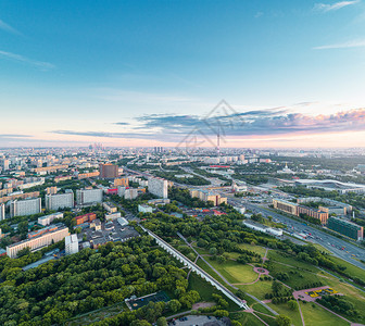 上市莫斯科在罗托基诺水龙式百万尼桥及其周围公园的空中观察夏季日落时有遥远的VDNKh公园Ostankino塔和莫斯科市商业中心摩图片