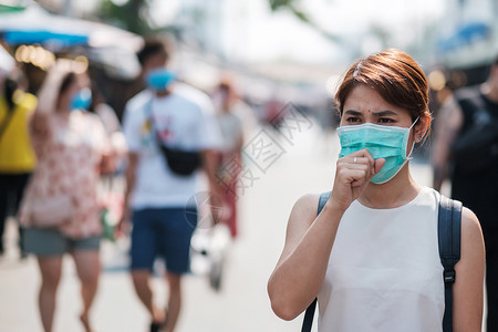 在城市户外佩戴口罩的游客图片