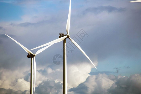 现代风车在阳光明媚的一天云雾多雨前景接近能源概念力量风电场活图片