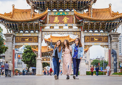著名的正方形在昆明金比广场旅行时3个亚裔幸福妇女一起散步和观光带着友情的旅行和游概念中文本是金马GoldenMarse移动的图片