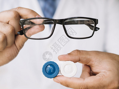 在室内镜片专家男医生展示一副黑色眼镜隐形分辨率和高品质美丽照片男医生展示一副黑色眼镜隐形高品质和分辨率美丽照片概念图片