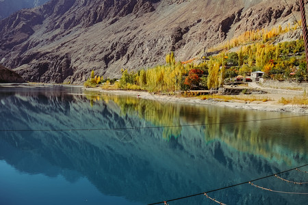 冰川印度教当地的在GupisGhizer山谷的小型村庄中在秋季和巴基斯坦GilgitBaltistan兴都库什山的多彩树木与青蓝图片