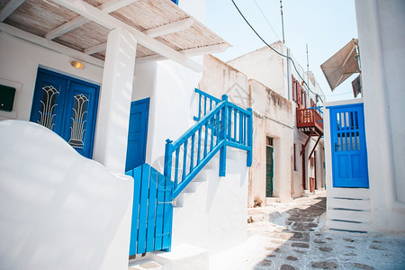 希腊美丽的建筑外表美丽环形风格在希腊狭窄的街道在希腊有蓝色的阳台楼梯和鲜花在小岛上别墅季节气候图片