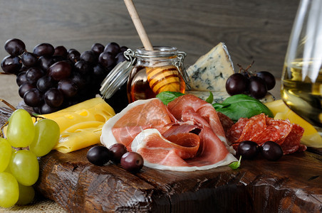 地中海用肉干熏香肠腊芝士橄榄和葡萄在木制背景上配菜格里西尼休息图片