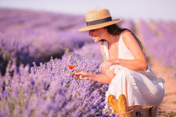 夏天紫花衣草地上美丽的年轻女在日落时紫花衣和白帽子下发现了一位红女郎紫色孩图片