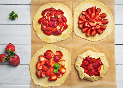 制作短结糕点和新鲜草莓的薄饼平板粉烤纸上四块饼干自制糕点平坦的馅饼烘烤图片