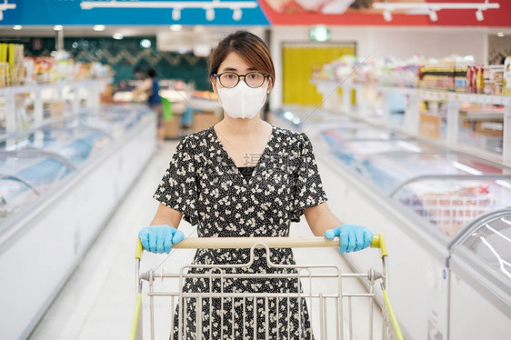 购物中心大车店铺亚洲妇女在超市或杂货店购物时佩戴防护面具和硝手套的亚洲妇女保护在共患19次大流行病后出现的社会混乱新正常和生活新图片