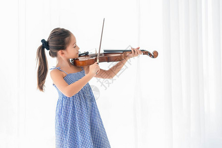 经典的在有白幕背景的卧室里玩小提琴的可爱女孩音乐和人们生活方式教育和娱乐概念亚洲音小提琴家亚洲音乐儿童在好和闲暇乐队艺术的图片