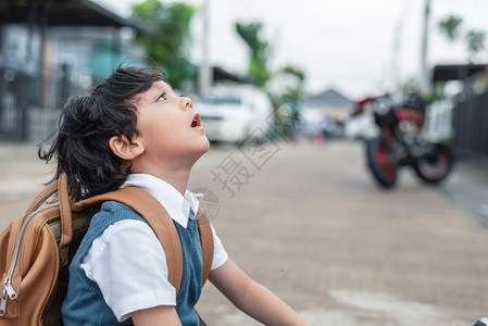 户外仰望天空的小男孩图片