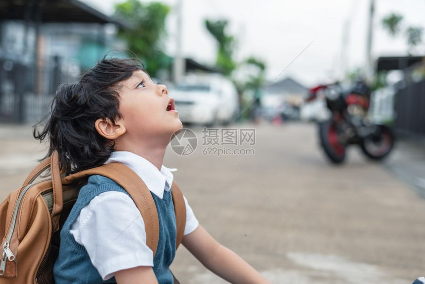 户外仰望天空的小男孩图片