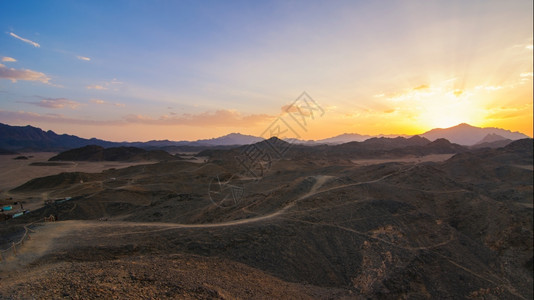 景观太阳美丽的地貌阿拉伯石头沙漠埃及日落时山峰高在沙漠游牧民小屋的左边全景图片