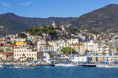 意大利圣雷莫2017年月4日从海上欣赏阳光明媚的一天乘船和游艇前往意大利古里亚山顶的圣雷莫拉皮尼亚老城和麦当娜德拉科斯塔教堂海岸图片