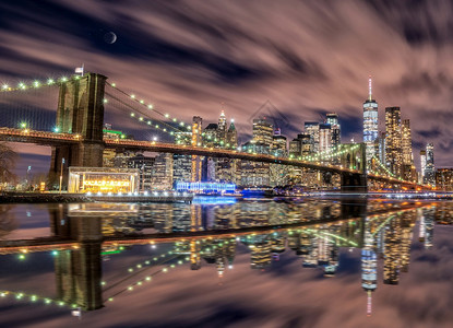 来自布鲁克林桥的纽约天线在蓝色时段月亮在哈德逊河上出现和反射区城市办公室图片