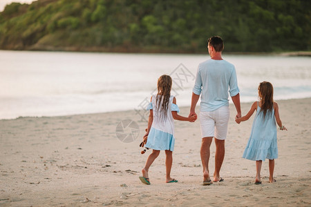 父亲和孩子在海滩上散步享受暑假家庭期幸福快乐美丽的家庭在热带海滩的度假节日女孩年轻的快乐图片