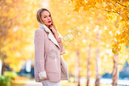 金发女郎美丽的人在秋天公园里温暖日子秋天落叶下概念美丽女人在秋天公园里落叶下喝咖啡季节肖像图片