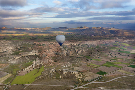 冒险一个气球在黎明时分飞越卡帕多西亚色彩缤纷的山谷土耳其一个气球飞越卡帕多西亚的山谷卡帕多克亚公园图片
