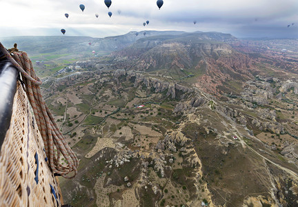 旅游一个五颜六色的气球在黎明时分飞越卡帕多西亚山谷的景色土耳其一个气球在卡帕多西亚的山谷上空飞行吸引力洞穴图片