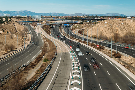 驾车旅行入口匝道旅行普通高速公路立交桥与汽车长时间曝光在西班牙马德里郊区拍摄故意运动模糊普通高速公路立交桥与汽车长时间曝光在西班牙马德里背景