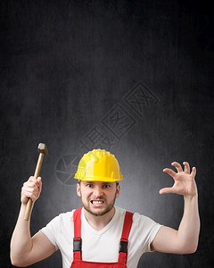 服务建造愤怒的筑工人手握锤子他愤怒的建筑工人画上一个用锤子的建筑工人业图片