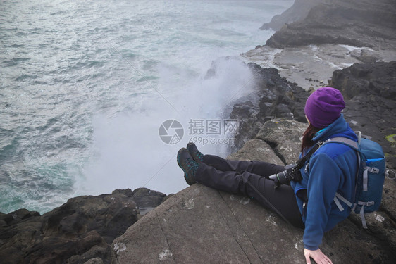 远足坐在法罗群岛瓦加尔悬崖上无法辨认的年轻女横向图像那里的Sorvagsvatn湖或Leitisvatn湖位于北大西洋法罗群岛光图片