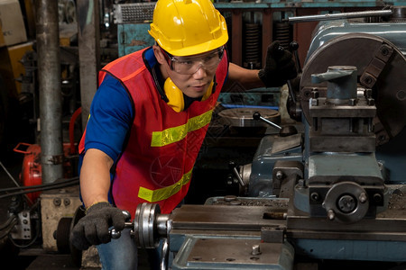 熟练的工厂人或程师在制造车间做机器工作业人员和制造劳动概念熟练的工厂人或程师在制造车间做机器工作控制维护机械图片