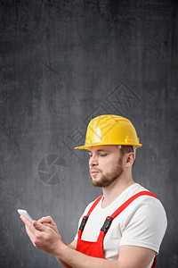 阅读技术员一名建筑工人使用智能手机的肖像一名工人使用智能手机的肖像保持图片