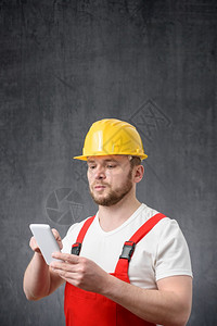 观看应用程序电话一名建筑工人使用智能手机的肖像一名工人使用智能手机的肖像图片