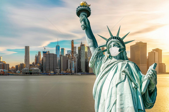 中央自由女神像戴外科面具当时Covid19在纽约克市风景河边联合州冠状流行建筑和上发生爆炸并带有旅游概念建造世界图片