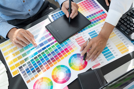 男手写笔图形设计师或创造合作使用图形平板和与同事在办公桌上的图案来涂色一种图片