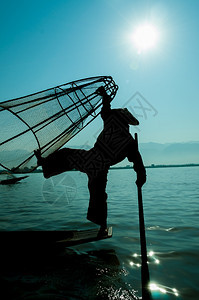 美丽的内莱湖渔民休游车轮站立在伊莱湖渔民的单脚上缅甸境内渔民的休泳车站立在一条脚上早晨传统的图片