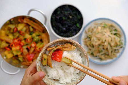 时间美食亚洲人顶端观光物每天用越南素食吃午餐越南素食煮豆腐和酱汁炒竹子白底海菜汤手握饭碗和吃图片