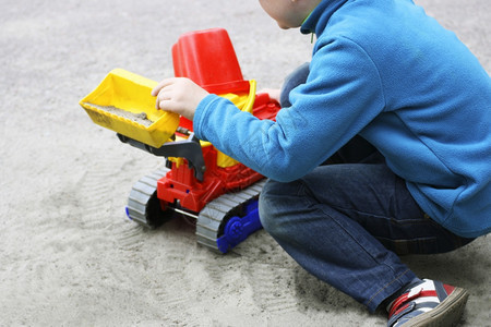 在户外玩玩具车的小男孩图片