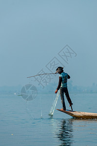 排茵莱湖的渔夫在一只脚上工作茵莱湖的渔夫在一只脚上工作缅甸波纹传统的图片