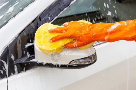 黄色的妇女手戴橙套和黄海绵冲洗侧面的黄色海绵冲洗镜面子现代汽车或清洁洗概念喷射人们图片