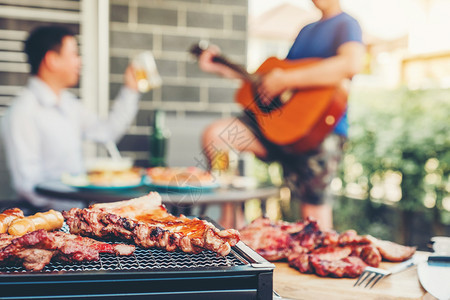 乐趣成人享受喝啤酒与烧烤和猪肉快乐地弹吉他玩家宴的派对朋友团体野餐图片