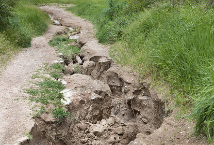 季节垃圾摇滚景观山路大雨后土壤侵蚀在绿种植被下大雨后山区道路上的土壤被毁坏山道上大雨后土壤流失图片