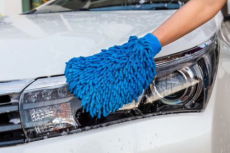 妇女手用蓝色微纤维织物洗头灯现代汽车或清洁洗概念以及修理干净的工人图片