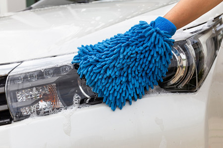妇女手用蓝色微纤维织物洗头灯现代汽车或清洁洗概念以及清洁器车辆喷射图片