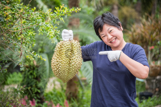 街道拥有都里安的亚洲女农民是泰国的水果之王阿西亚有一个钉子壳在泰国街头小吃市场上可以买到甜美食品和水果市场而拥有都里安的亚洲农户图片