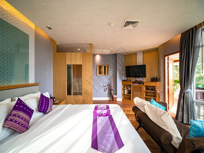 睡觉豪华房间装饰品有棕色木地板和家具温暖的灯光和窗玻璃外观泰国旅馆度假村采取公寓图片