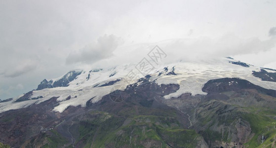 俄罗斯联邦乌古壮山北高加索地貌下雪和厚云的高加索山丘夏季日俄罗斯联邦爬坡道场景全图片