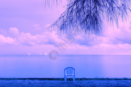 黄昏沙滩上平静的海景和空椅子图片