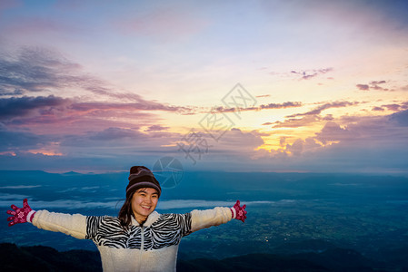 女士穿着毛衣的游客站在伸展的手臂上在看清日出时PhuThapBoekViewpointPhetchabun泰国女观日出森林和山区图片