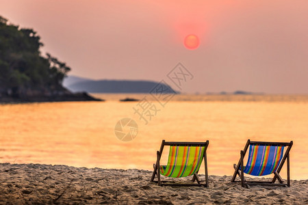 日出户外加勒比海在沙热带滩和海浪两座甲板椅上美日初落夏在泰国尚塔胡里岛的礼帽卡休海滩上度过图片