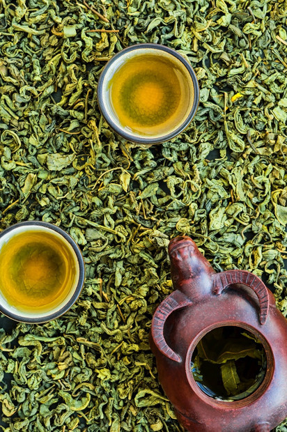 草本植物有机的茶杯中热绿石头桌上的陶瓷茶壶布局上的发色茶叶分散在桌子上从最小值以芳香图片