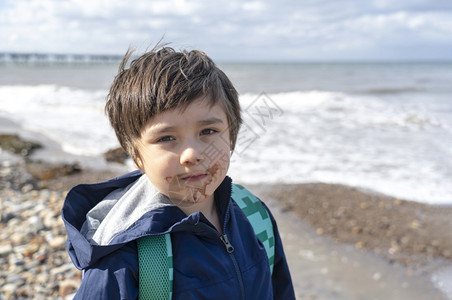 学步的儿童男生基德头被射中孩子用脏嘴吃巧克力冰淇淋和模糊的海景背康迪拍摄了快乐的孩子独自站着看镜头带微笑的脸看摄影机一个男孩在夏图片