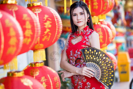 节日亚裔女身着传统青山红衣装饰配有纸灯上面写着中文字母祝福是华元新年的幸运赞美奖章福吸引人的图片