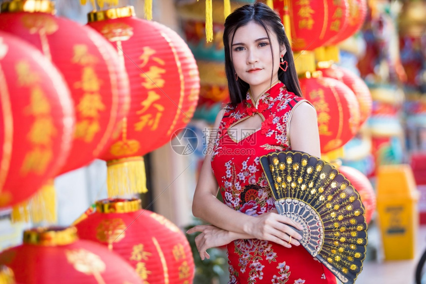 节日亚裔女身着传统青山红衣装饰配有纸灯上面写着中文字母祝福是华元新年的幸运赞美奖章福吸引人的图片
