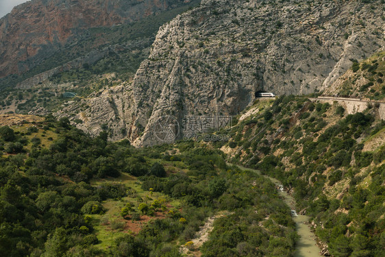 安达卢西亚州阿代尔斯的一个大山谷河边有一条流四周环绕着山脉和穿过洞隧道的火车结石白色的轨图片